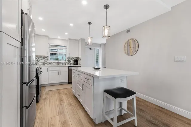 a kitchen with a refrigerator a sink and cabinets