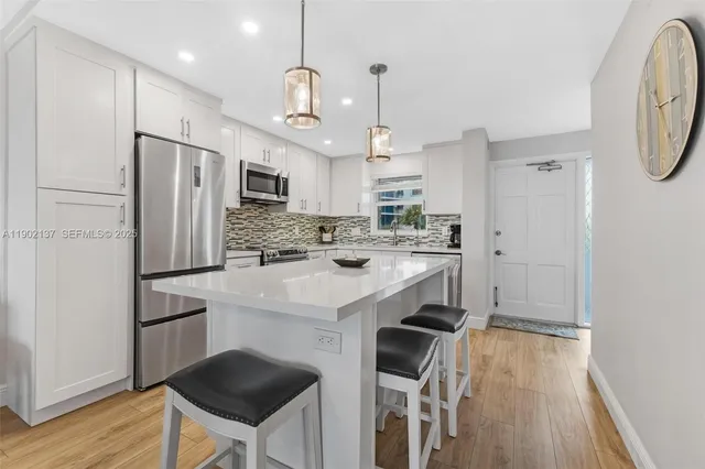 a kitchen with kitchen island a refrigerator stove and microwave