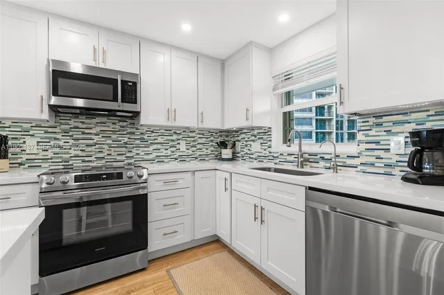a kitchen with stainless steel appliances granite countertop a sink stove and microwave