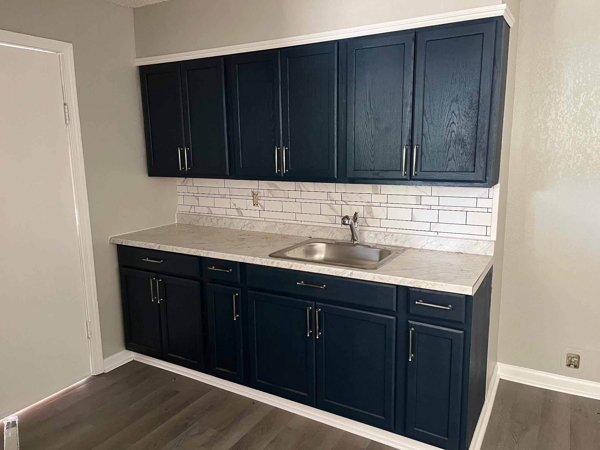 518 Harahan Road Memphis, TN 38109 - Photo 5 of 9 Kitchen featuring light countertops, backsplash, and dark wood-type flooring