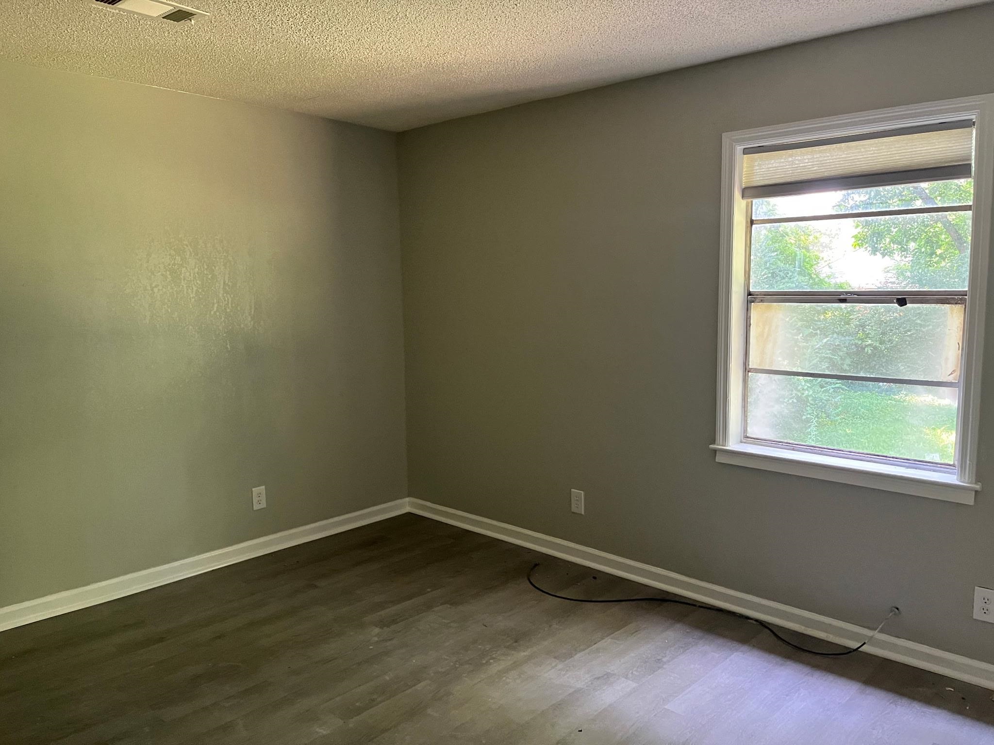 518 Harahan Road Memphis, TN 38109 - Photo 8 of 9 Empty room with wood finished floors and a textured ceiling