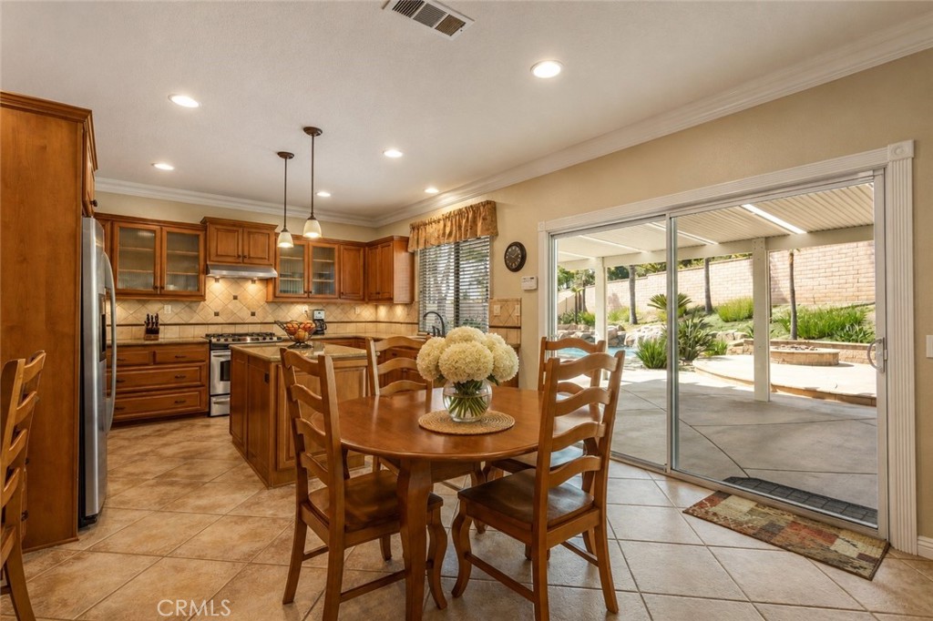 33351 Nicholas Common Temecula, CA 92592 - Photo 12 of 42 a kitchen with stainless steel appliances kitchen island granite countertop a table and chairs