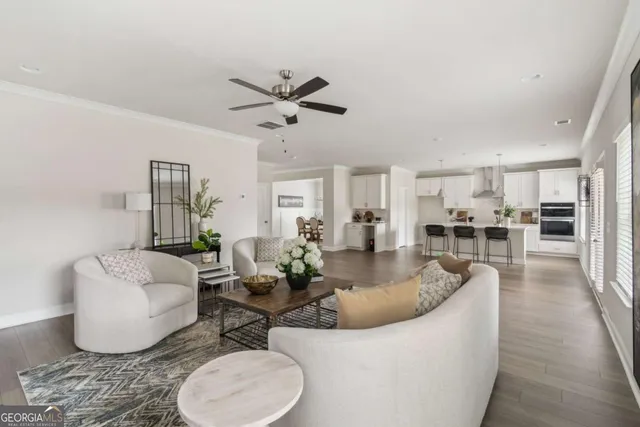 a living room with furniture and a view of kitchen