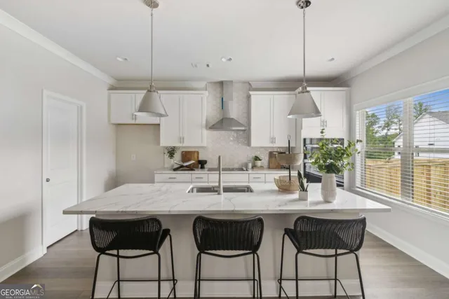 a kitchen with granite countertop a table chairs stove and cabinets