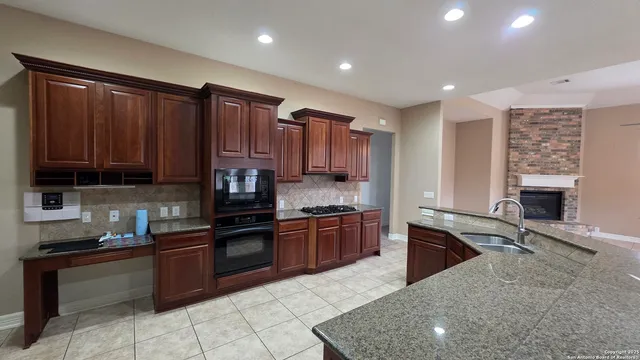 a kitchen with stainless steel appliances granite countertop a stove sink and cabinets