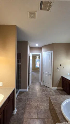 a view of a hallway with bathroom and mirror