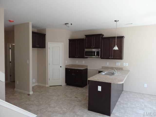 6919 Spanglers Spring Way Raleigh, NC 27610 - Photo 3 of 13 a kitchen with stainless steel appliances granite countertop a sink a stove a refrigerator a microwave a sink and cabinets