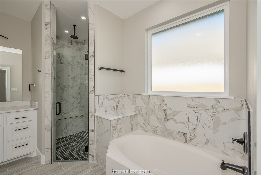 2908 GOLDBERG Drive Bryan, TX 77808 - Photo 36 of 44 Master bathroom retreat features soaking tub, natural light, walk in shower with decorative ceramic tile and glass shower enclosure.