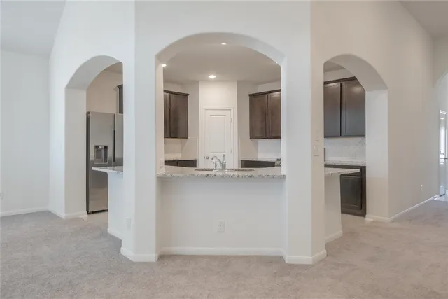 a view of kitchen with kitchen island and stainless steel appliances