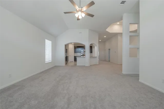 a view of a big room with chandelier fan and windows