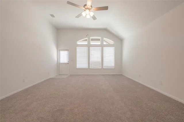 an empty room with windows and fan