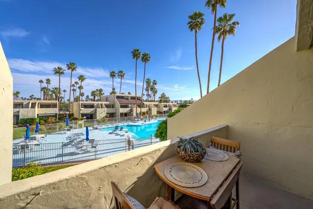 a view of a balcony dining area and swimming pool