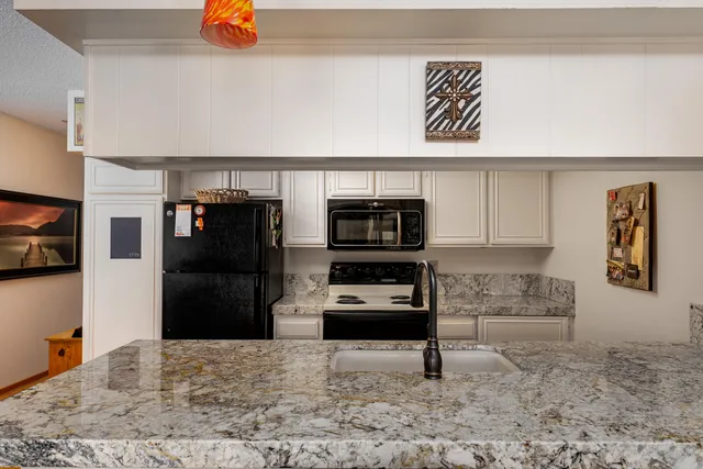 a kitchen with stainless steel appliances granite countertop a refrigerator and a stove