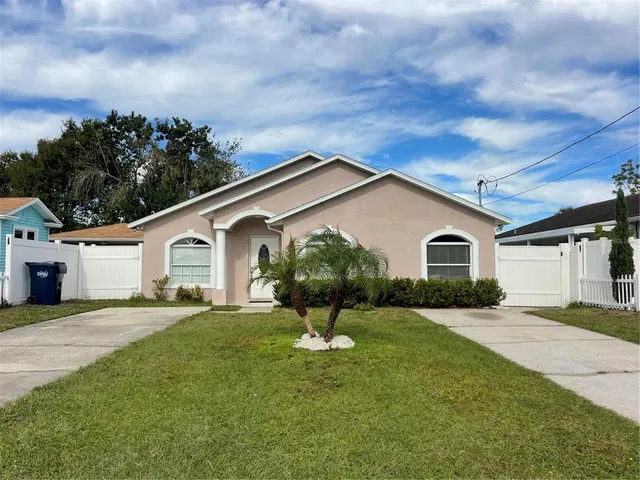 a view of a house with a yard and fence