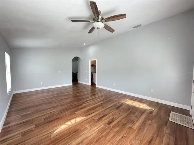 a view of empty room with wooden floor