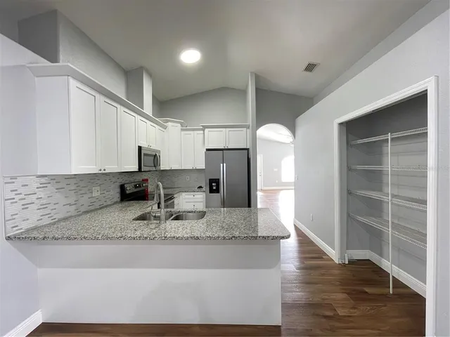 a large kitchen with kitchen island granite countertop a large counter top stainless steel appliances and cabinets