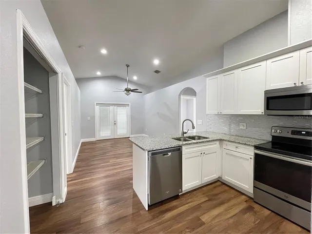 a kitchen with stainless steel appliances granite countertop a sink and cabinets
