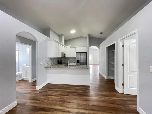 a view of kitchen with kitchen island stainless steel appliances refrigerator stove microwave and cabinets