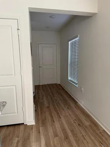 a view of a room with wooden floor and white walls