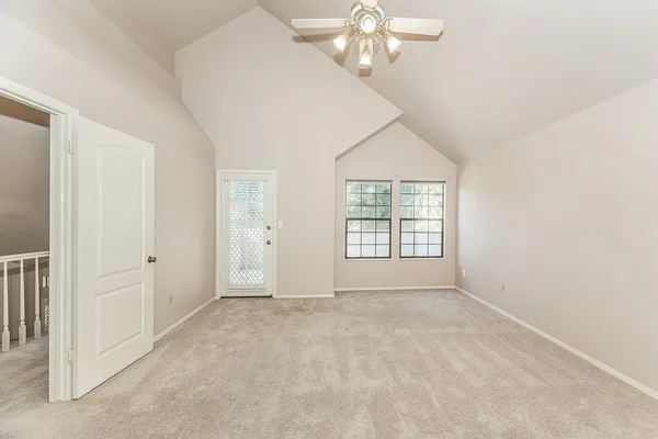 a view of an empty room with a chandelier fan