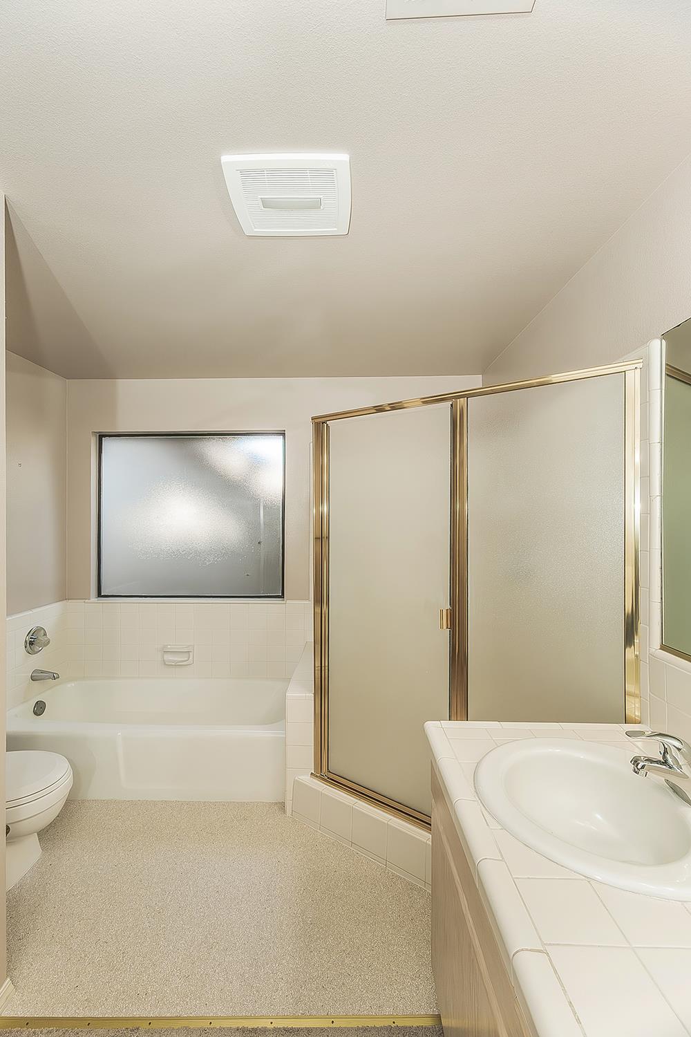 1282 West Flora Avenue Reedley, CA 93654 - Photo 22 of 49 a bathroom with a sink a toilet and shower