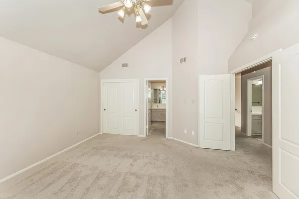 an empty room with windows and fan