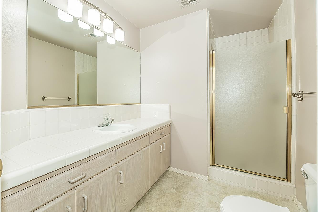 1282 West Flora Avenue Reedley, CA 93654 - Photo 26 of 49 a bathroom with a sink a toilet and mirror