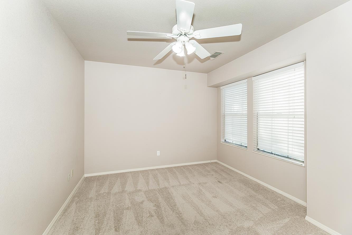 1282 West Flora Avenue Reedley, CA 93654 - Photo 28 of 49 an empty room with chandelier fan and windows
