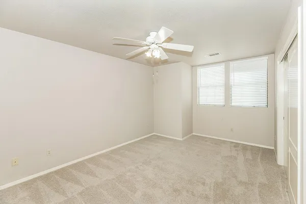 a view of an empty room with closet and a window