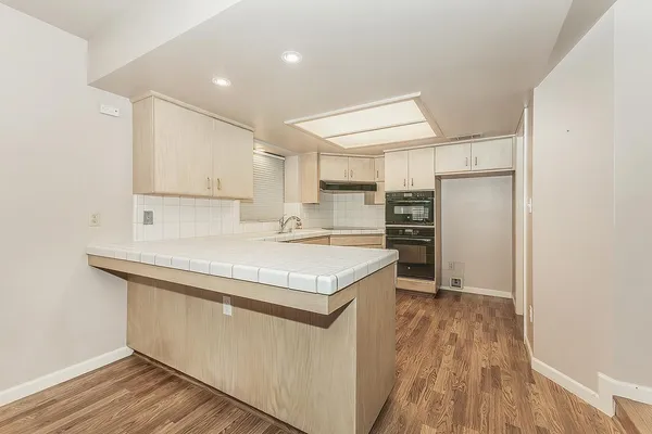 a kitchen with granite countertop white cabinets and white appliances