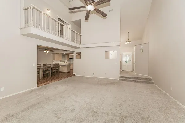 an empty room with white walls and ceiling fan
