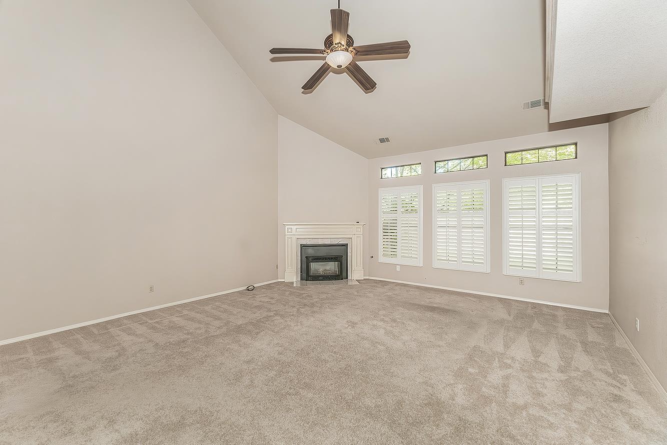 1282 West Flora Avenue Reedley, CA 93654 - Photo 7 of 49 an empty room with chandelier fan and windows