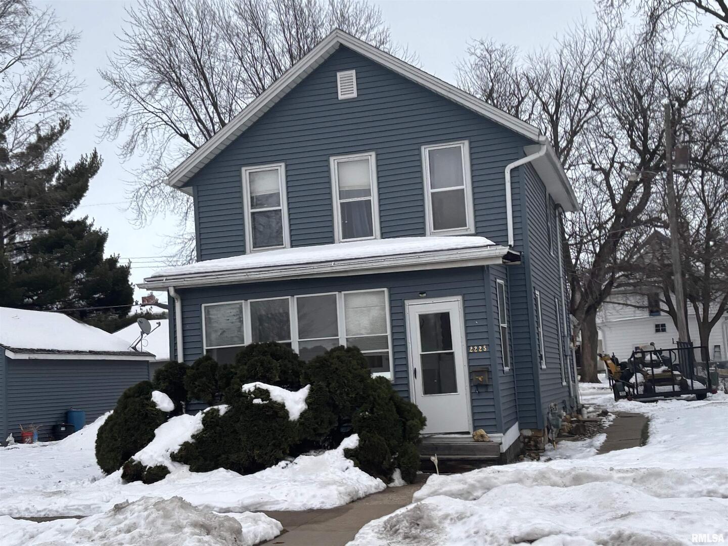 a front view of a house with a yard covered in snow