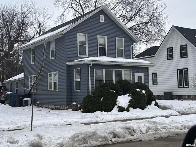 a front view of a house with a yard covered in snow