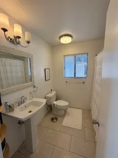 a bathroom with a sink mirror and toilet