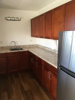 a kitchen with stainless steel appliances granite countertop a sink refrigerator and cabinets