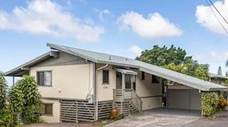 a front view of a house with plants