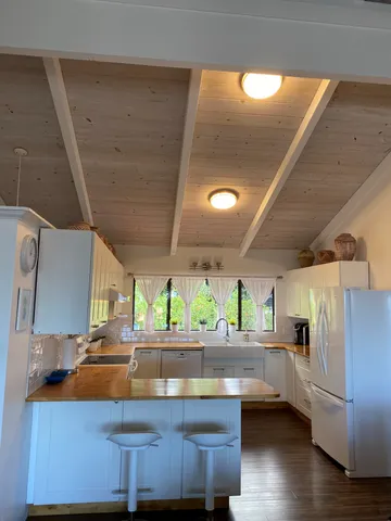 a kitchen with stainless steel appliances wooden floor and large windows