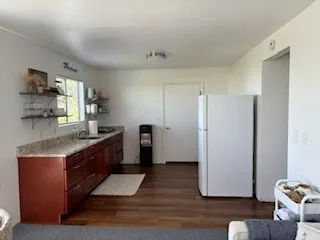 a kitchen with granite countertop a refrigerator and a sink