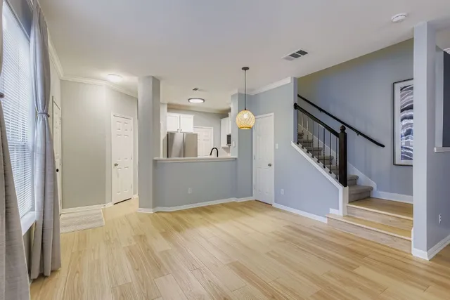 a view of a hallway with wooden floor and staircase