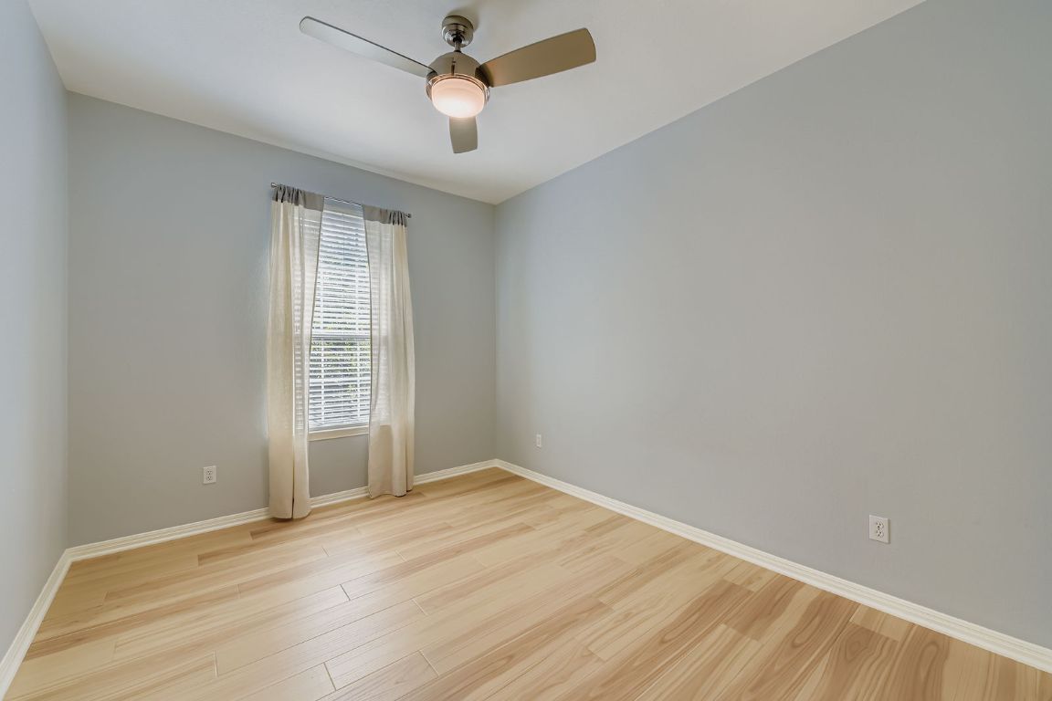 8518 Cahill Drive, Unit 20 Austin, TX 78729 - Photo 17 of 36 an empty room with wooden floor and windows