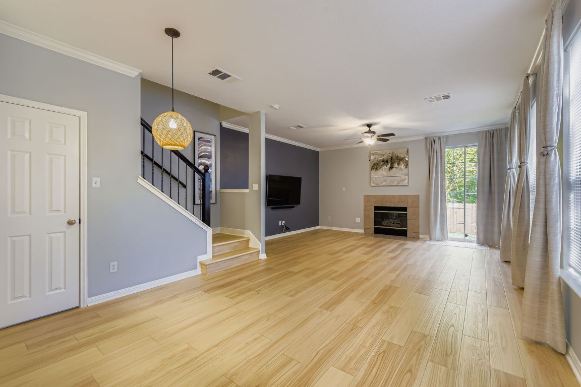 8518 Cahill Drive, Unit 20 Austin, TX 78729 - Photo 7 of 36 a view of an empty room with wooden floor fireplace and a window