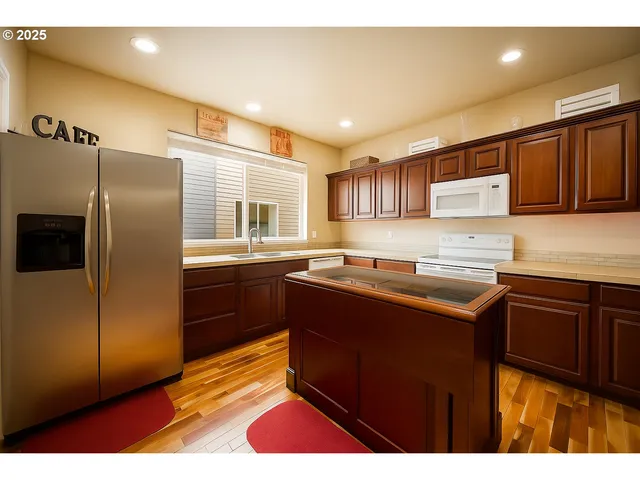 a kitchen with kitchen island granite countertop a sink cabinets and window