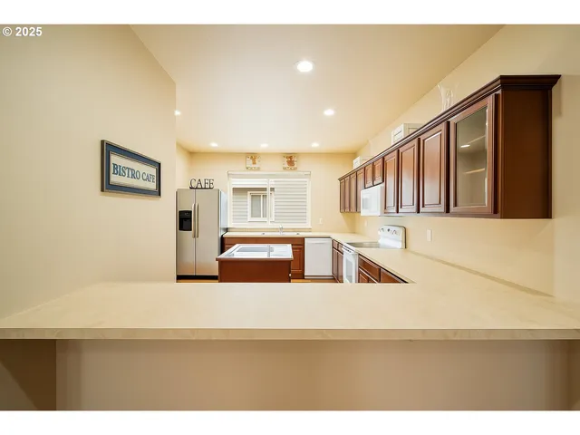 a kitchen with stainless steel appliances granite countertop a refrigerator and a sink