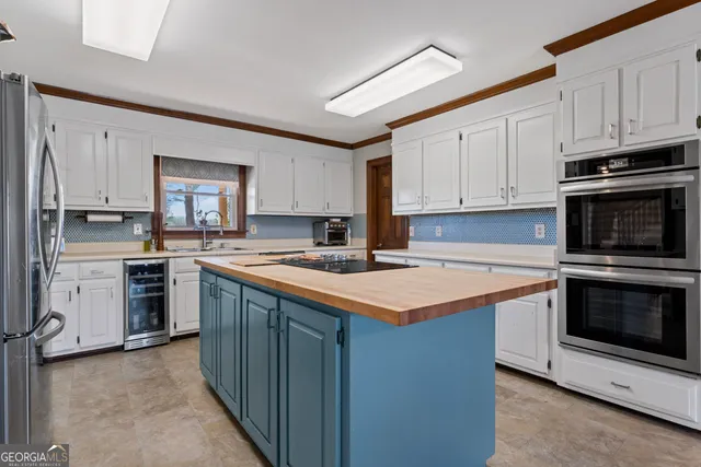 a kitchen with stainless steel appliances granite countertop a stove top oven a sink and a refrigerator