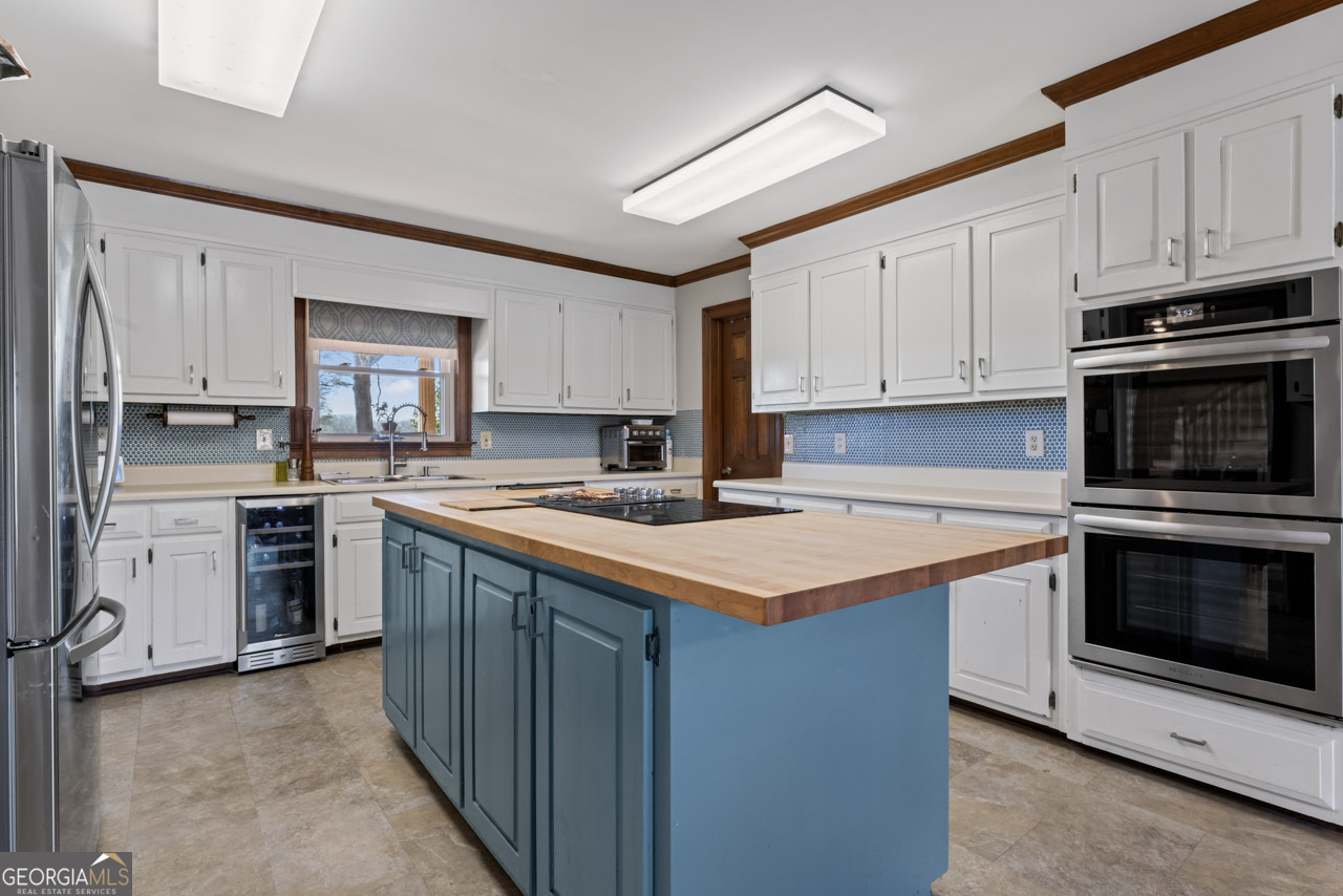 2940 East Lake Road McDonough, GA 30252 - Photo 15 of 47 a kitchen with stainless steel appliances granite countertop a stove top oven a sink and a refrigerator