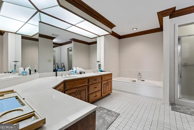 a spacious bathroom with a double vanity sink a mirror and a bathtub