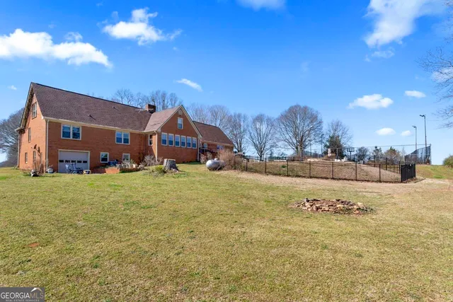 a view of an house with backyard and a tree