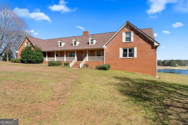 a front view of a house with a yard and potted plants