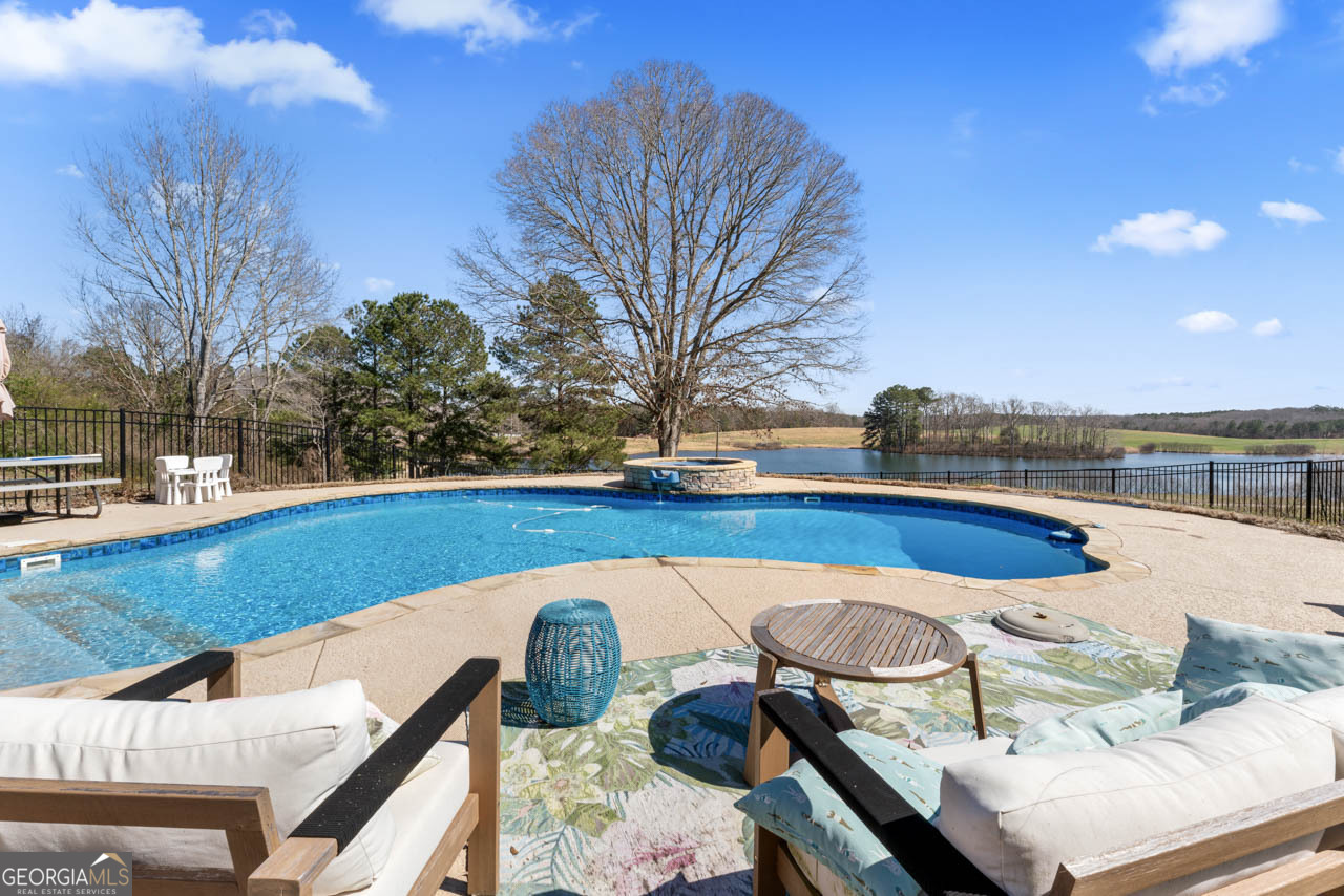 2940 East Lake Road McDonough, GA 30252 - Photo 8 of 47 a view of swimming pool with lounge chair and dinning table under an umbrella